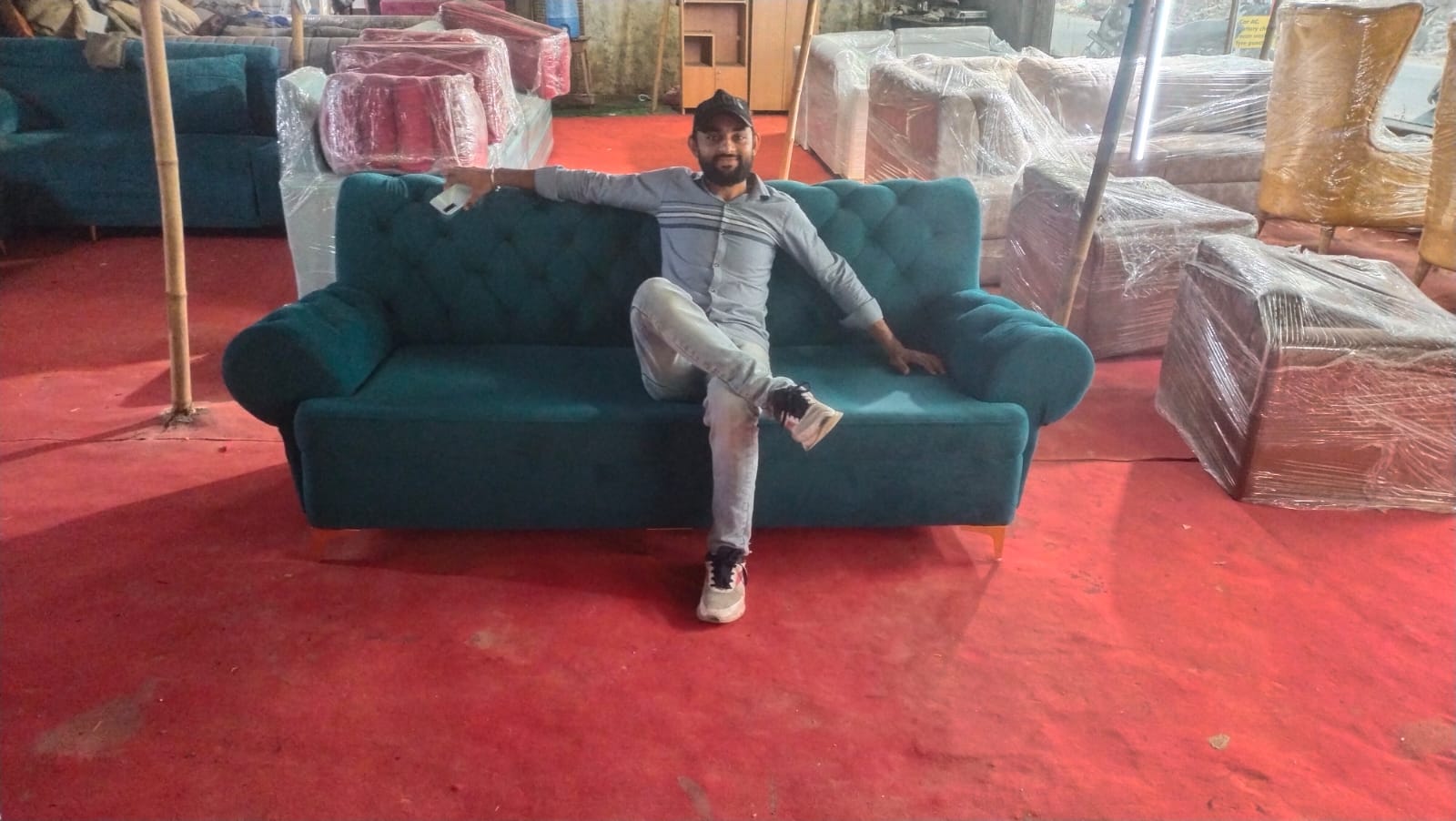 NS Furniture artisan with completed tufted turquoise sofa in Noida workshop